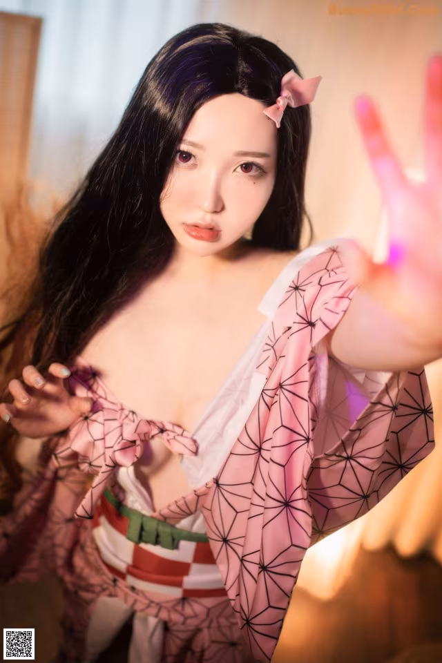 A woman in a pink kimono is posing for a picture.