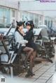 A couple of women sitting on top of a bunch of chairs.