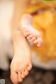 A close up of a person's bare feet on a bed.