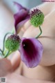 A close up of a person holding a purple flower.