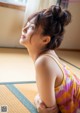 A woman sitting on a tatami mat in a room.