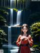 A woman in a red kimono standing in front of a waterfall.